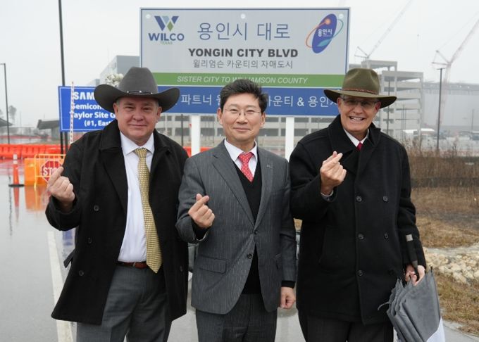 이상일 용인특례시장(가운데)이 현지시간 1월 9일 빌 그래벨 윌리엄슨 카운티청장(오른쪽)과 테일러시 삼성전자 파운드리 시설 신축공사장 앞에 설치된 '용인시 대로' 명예도로표지판 앞에서 기념촬영을 하고 있다