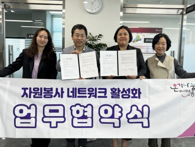 박명일 시흥시자원봉사센터장(왼쪽에서 두번째)과 윤지은 아우룸사회적협동조합 이사장이 업무협약서를 들고 기념촬영하고 있다