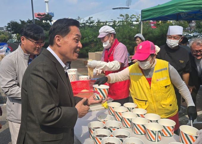 이재준 수원시장과 이동노동자들이 1일 오전 11시 수원종합운동장에서 수원시노사민정과 수원시자원봉사센터 협업으로 열린 ‘찾아가는 밥차’를 찾아 짜장면과 탕수육을 배식받고 있다.