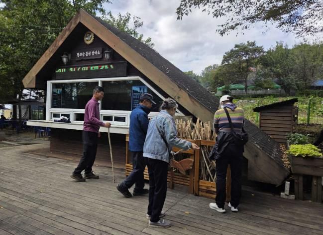 등산객들이 광교산 등산 안내소 앞에 있는 지팡이를 고르고 있다.