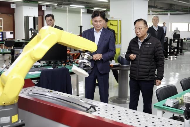 ㈜에이엘로봇의 강대희 대표가 조용익 부천시장에게 로봇팔을 이용한 연마공정을 시연하고 있다.